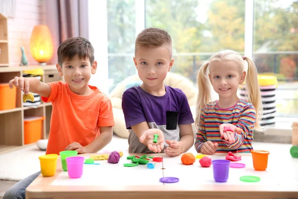 Kleine kinderen die zich bezighouden met playdough modelleren op kinderdagverblijf — Stockfoto