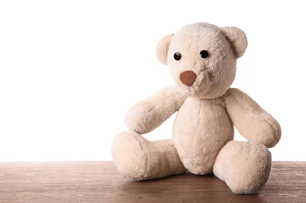 Niedlicher Teddybär auf Tisch vor weißem Hintergrund — Stockfoto