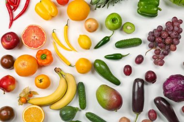 Meyve ve sebze gökkuşağı renkleri, düz beyaz arka plan üzerinde yapılmış yaratıcı kompozisyon yatıyordu