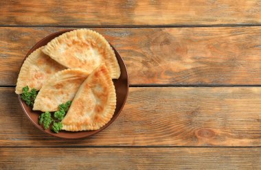 Ahşap arka plan üzerinde derin kızarmış samosas plakalı