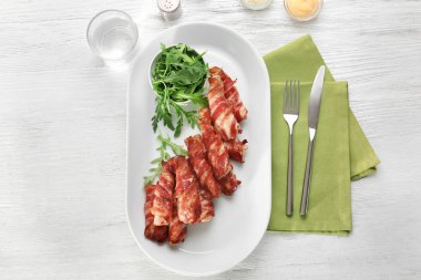 Plaka pastırmalı tavuk nuggets masanın üzerine sarılmış.