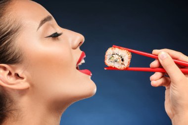 Güzel genç kadın suşi ile renk arka plan üzerinde rulo