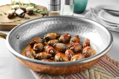 Tarihleri kızartma tavası pastırma ile sarılmış