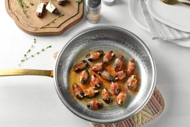 Tarihleri kızartma tavası pastırma ile sarılmış 