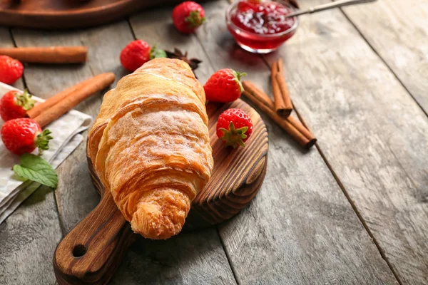 Wooden board with tasty croissant on table — Stock Photo, Image