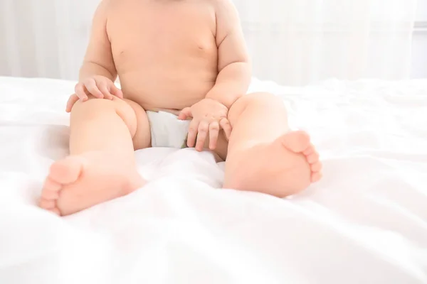 Pequeno bebê sentado na cama, close-up — Fotografia de Stock