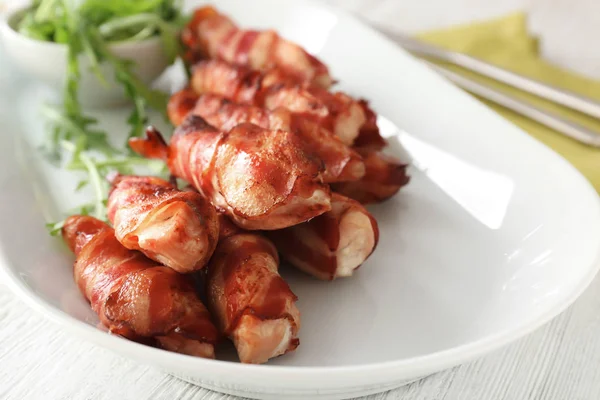 Plade med bacon indpakket kylling klumper på bordet, closeup - Stock-foto