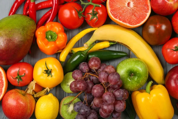 Kreative Komposition aus Obst und Gemüse in Regenbogenfarben auf Holzgrund, flache Lage — Stockfoto