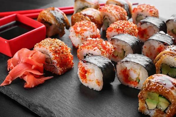 Leisteen plaat met lekkere sushi rolt op tafel — Stockfoto