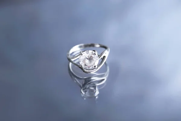 Hermoso anillo de compromiso en superficie reflectante — Foto de Stock