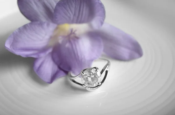 Belle bague de fiançailles et fleur, gros plan — Photo