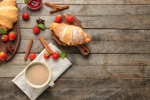 Komposisi dengan croissant lezat dan kopi pada latar belakang kayu — Stok Foto