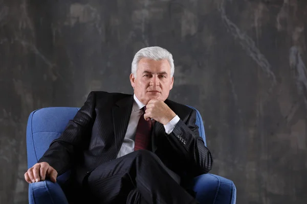 mature man sitting in armchair