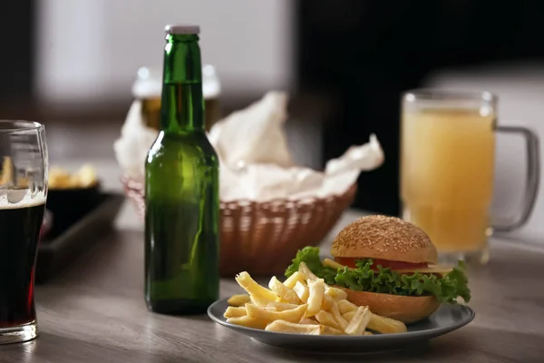 Cerveza y hamburguesa en la mesa — Foto de Stock