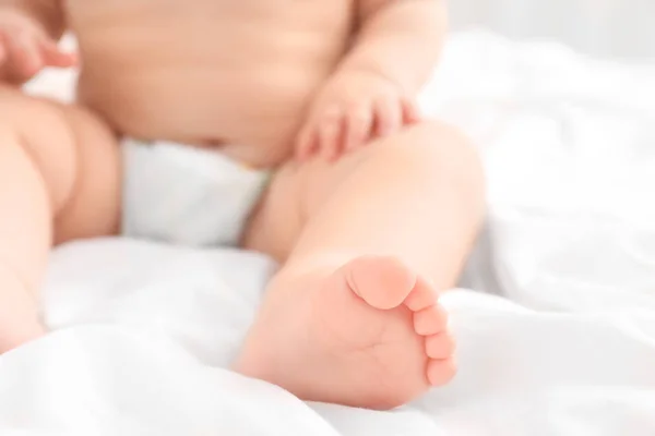 Pequeño bebé sentado en la cama, primer plano — Foto de Stock