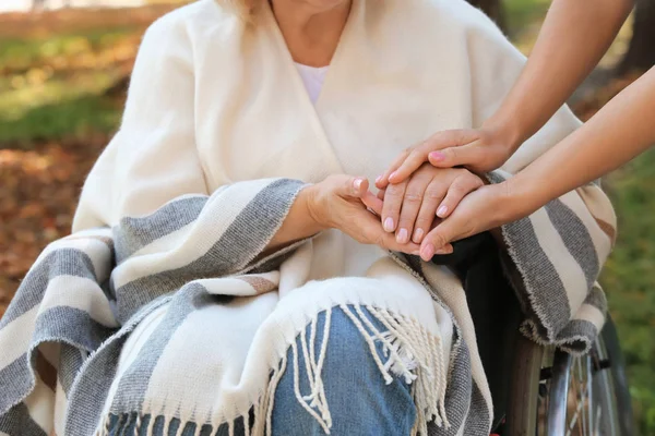 Senior vrouw en jonge mantelzorger — Stockfoto