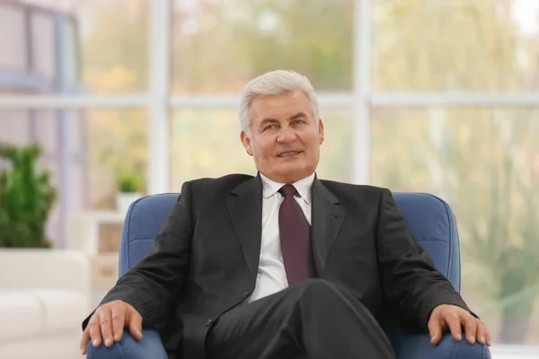 Reifer Mann sitzt im Sessel — Stockfoto