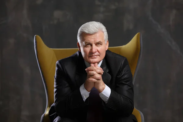 mature man sitting in armchair