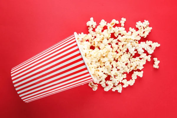 Cup with popcorn on color background — Stock Photo, Image
