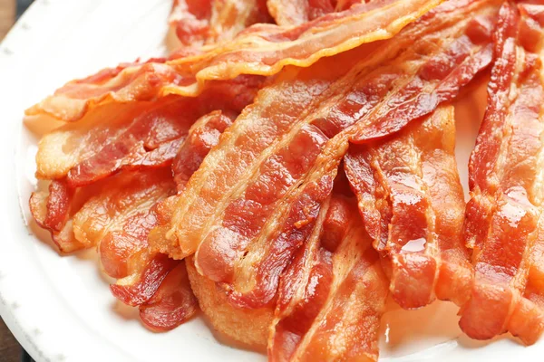 Kokta bacon skivor på tallrik, närbild — Stockfoto