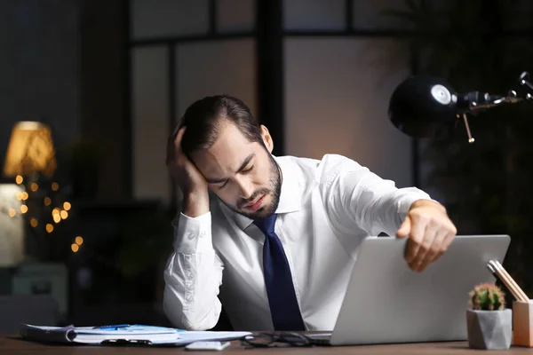 Hombre joven cansado usando el ordenador portátil —  Fotos de Stock