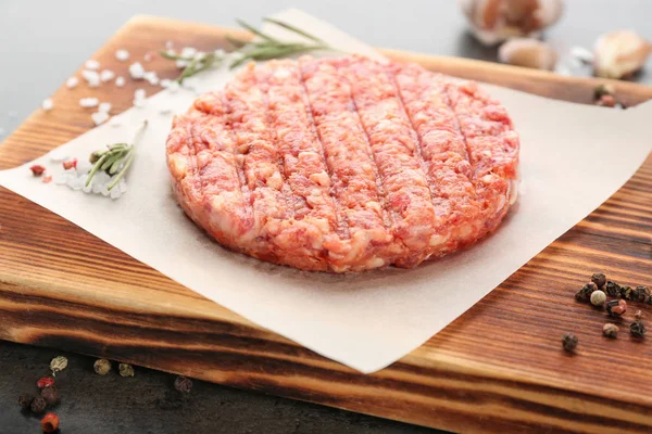 Wooden board with raw burger — Stock Photo, Image