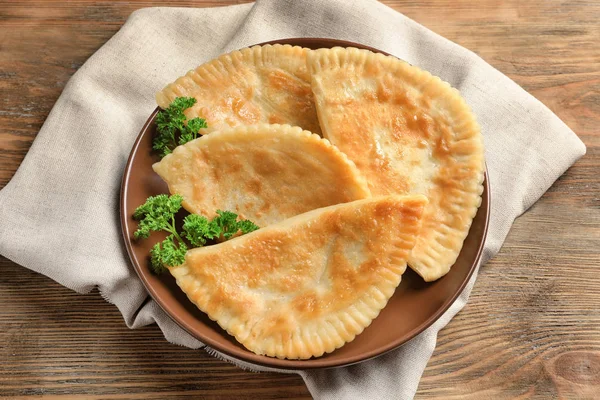 Placa con samosas fritas sobre fondo de madera — Foto de Stock