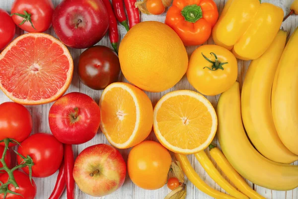 Творча композиція з фруктів та овочів у веселкових кольорах на дерев'яному фоні, плоска — стокове фото
