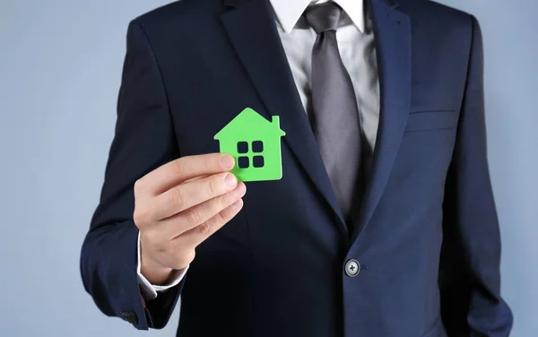 Real estate agent holding house model — Stock Photo, Image