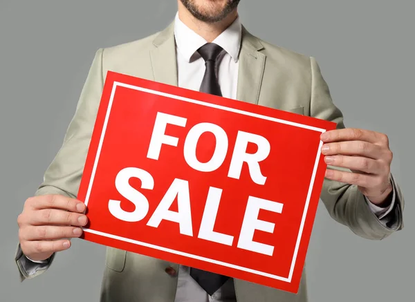 Real estate agent holding "For sale" sign — Stock Photo, Image