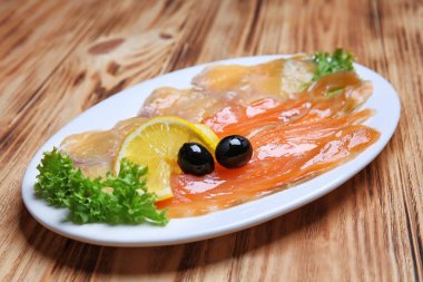 Lezzetli balık carpaccio ahşap masa üzerinde plaka
