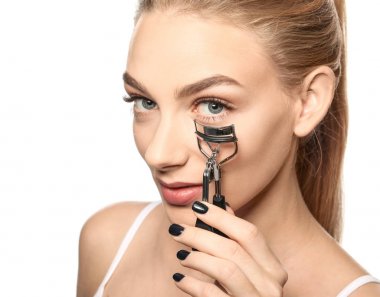 Kirpik kıvırıcı beyaz arka plan üzerinde olan güzel kadın