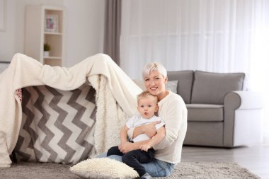 Genç kadın bebeği ile evde oynarken