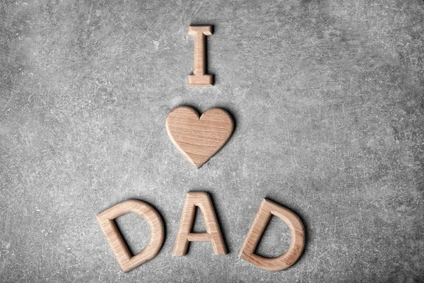 Isänpäivän tervehdys lauseella "Rakastan isää", joka on tehty harmaalla pohjalla olevista kirjaimista — kuvapankkivalokuva