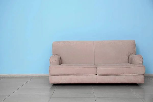 Stílusos kanapé-közel színes fal beltéri — Stock Fotó