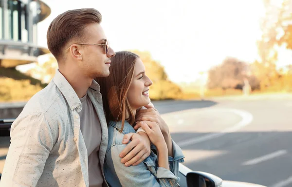 Mutlu genç çift ayakta modern araç açık havada yakınındaki — Stok fotoğraf