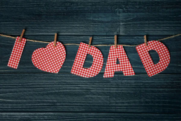 Frase "Amo papà" fatta di lettere di carta come saluto per la festa del papà su spago sullo sfondo di legno — Foto Stock