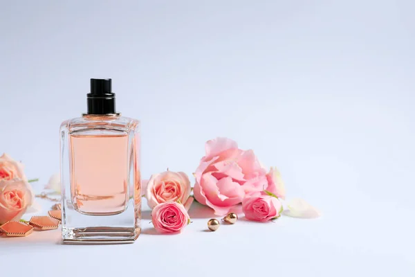 Пляшка парфумів з квітами на білому тлі — стокове фото
