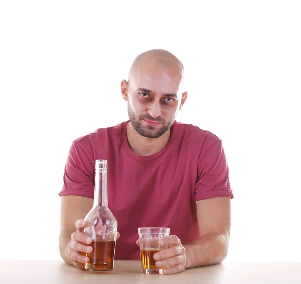 Részeg ember ül az asztal, a whiskey, fehér háttérrel. Alkoholizmus-koncepció — Stock Fotó