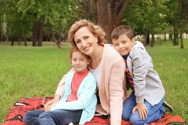 Feliz mujer mayor con nietos en el parque — Foto de Stock