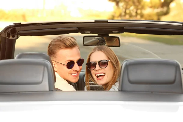 Счастливая молодая пара в машине в дороге — стоковое фото