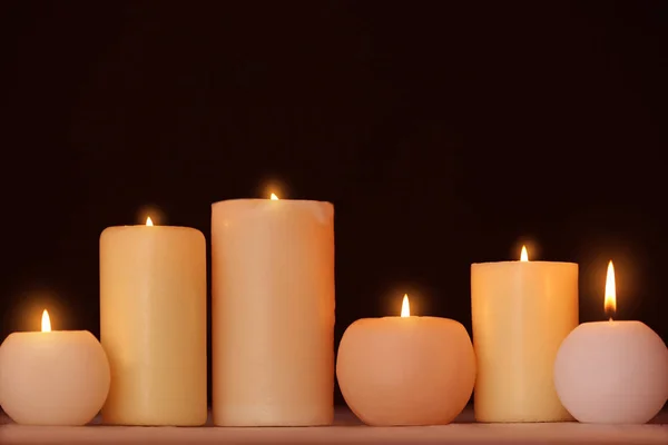 Velas ardientes sobre la mesa sobre fondo negro —  Fotos de Stock