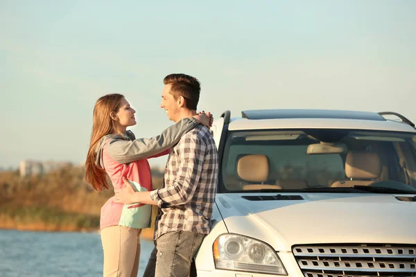 Schönes junges Paar steht neben Auto im Freien — Stockfoto