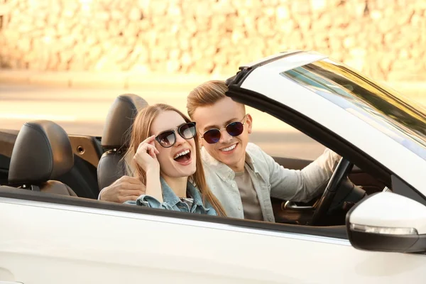 Happy young couple in car on road trip — Stock Photo, Image