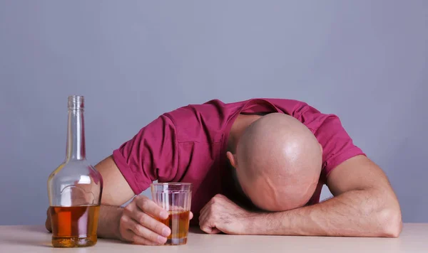 위스키와 함께 테이블에 앉아 술에 취해 남자입니다. 알코올 중독의 개념 — 스톡 사진