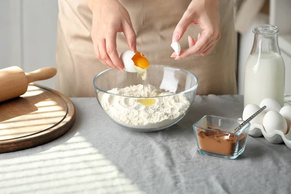Женщина готовит тесто для булочек с корицей на кухне — стоковое фото