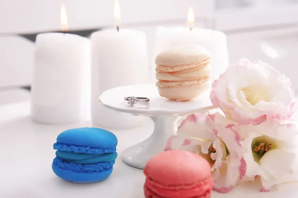 Nişan yüzüğü, macarons ve masaya çiçek güzel kompozisyonu — Stok fotoğraf