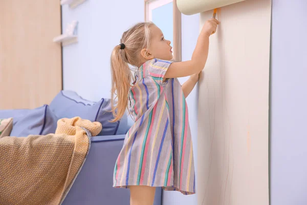 Pouco bonito menina desenho no rolo de papel dentro de casa — Fotografia de Stock