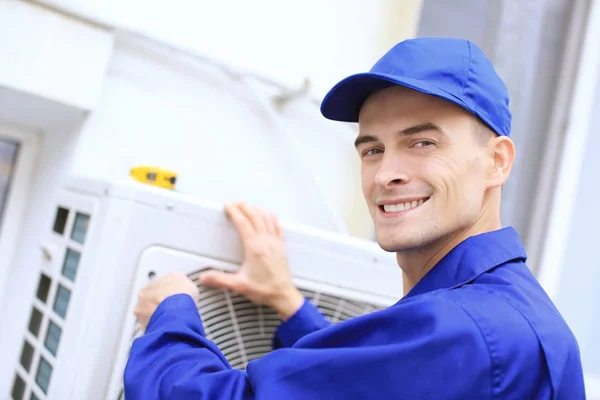 Männlicher Techniker repariert Klimaanlage im Freien — Stockfoto