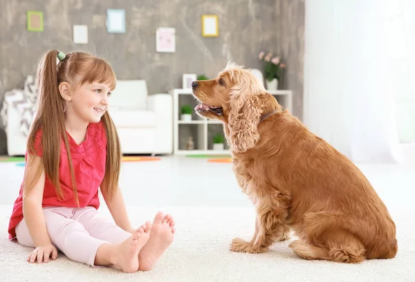 Schattig klein meisje met hond thuis — Stockfoto